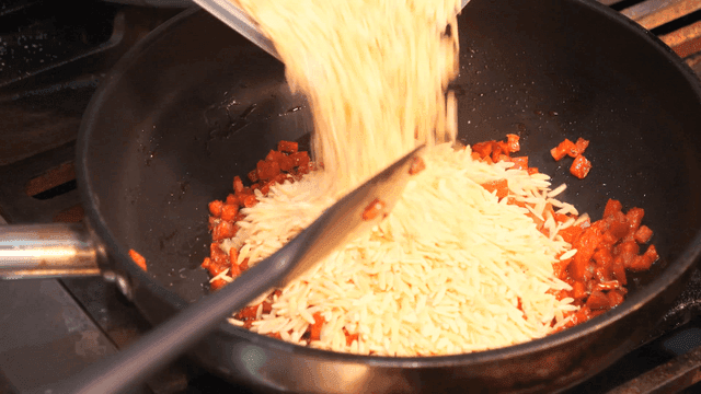 Pasta poured into pan containing chorizo