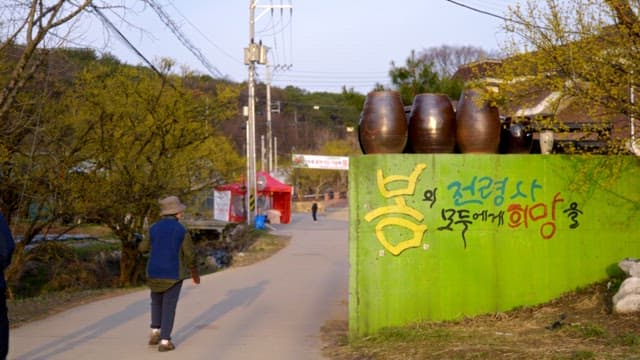 사람들이 걷고 있는 산수유마을의 조용한 시골길