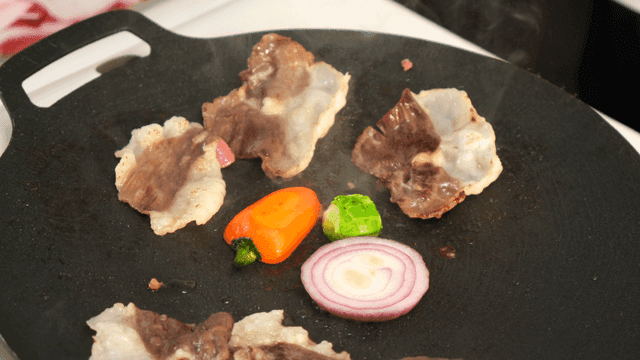 Grilling beef and vegetables on pan