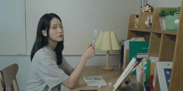 책상에 앉아 어딘가를 쳐다보는 여성