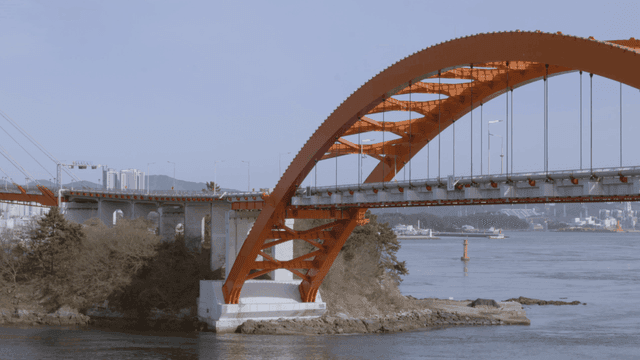 Large orange bridge over calm river