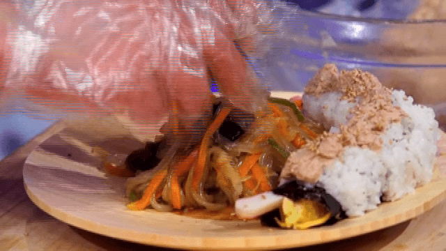 나무 접시에 놓인 김밥과 잡채