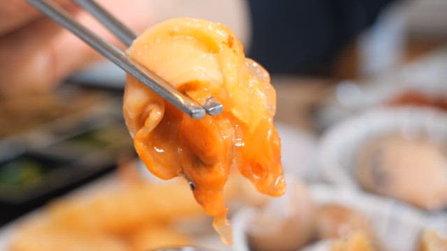 젓가락으로 고둥에서 소라살을 빼내는 모습