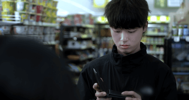 Young man rummaging through his wallet at convenience store