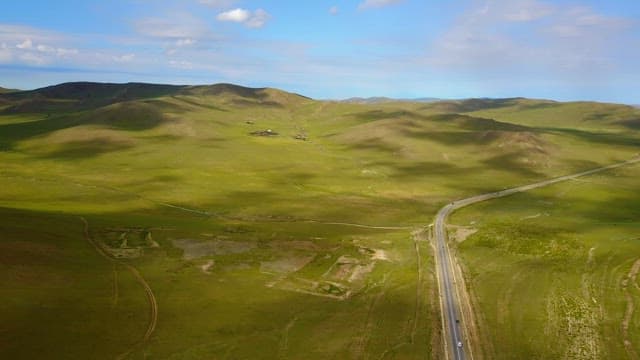 Vast green landscape with a winding road