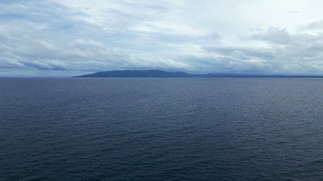 Vast ocean with distant mountains