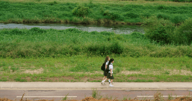 강가 산책로를 같이 이어폰을 나눠 끼고 걷는 두 학생