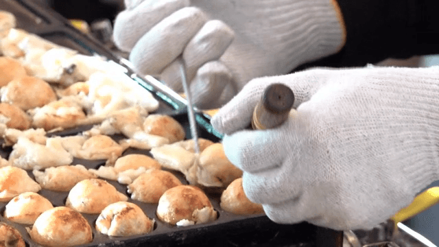 Takoyaki being cooked on a hot grill