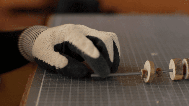 장갑 낀 손으로 나무 조각 조립