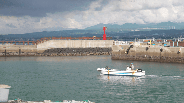 Small boat sailing through quiet harbor