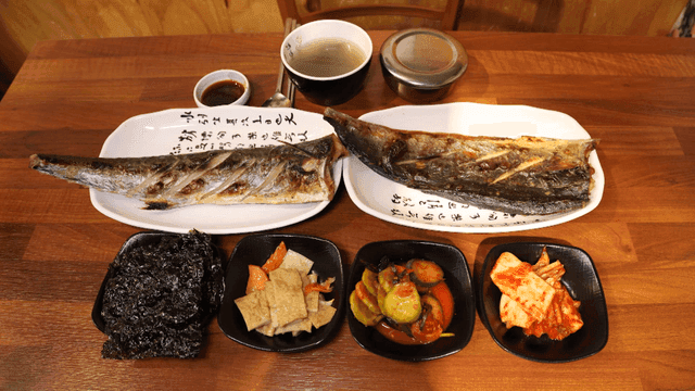 Grilled fish and side dishes on table