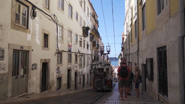 Tourists Waiting to Board the Tram Through the City Alleys