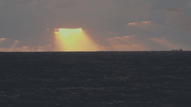Sunlight breaking through clouds over the sea