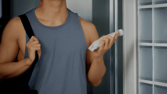 가방을 매고 단백질 셰이크를 흔들며 들어오는 남자