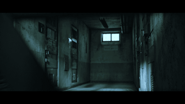 Back of man in suit walking through dark detention center