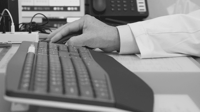 책상에서 컴퓨터 마우스를 사용하는 손