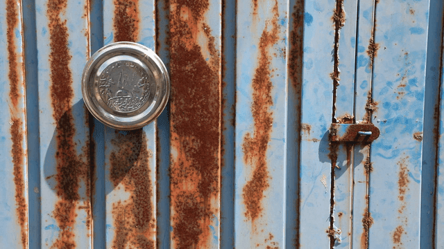 Rusty blue metal door with round handle