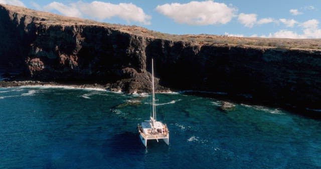 Yacht sailing near a rocky coastline