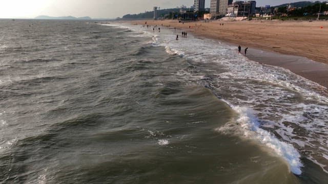 모래 해변에 부딪히는 파도