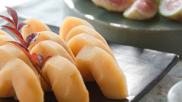 Figs and persimmon slices neatly arranged on a plate