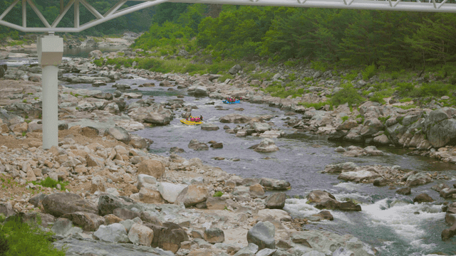 바위가 많은 강에서 래프팅을 즐기는 사람들