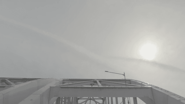 달리는 차 안에서 보는 흐린 하늘 아래 다리 구조물