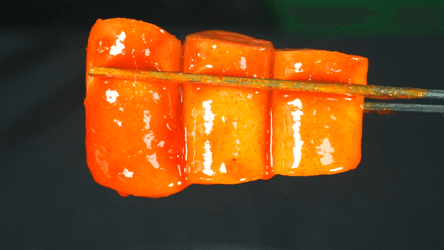 Spicy tteokbokki picked up with chopsticks