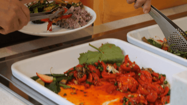 Sight of placing Korean side dishes on plate along with rice.