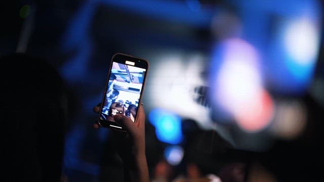 People Filming Exciting Performances with Cell Phones