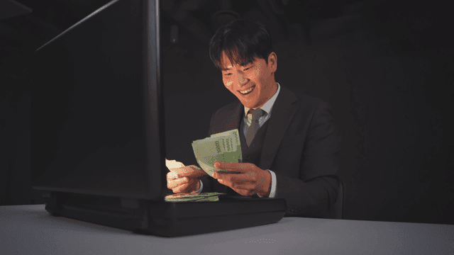 Man in a suit opening a briefcase with money