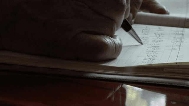 노트에 글을 쓰는 노인