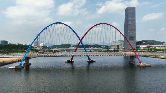 도시 스카이라인이 보이는 강 위의 독특한 다리