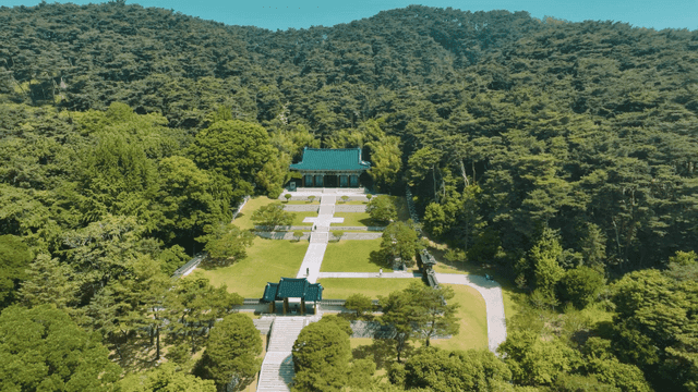 Traditional Hanok shrine surrounded by lush forest
