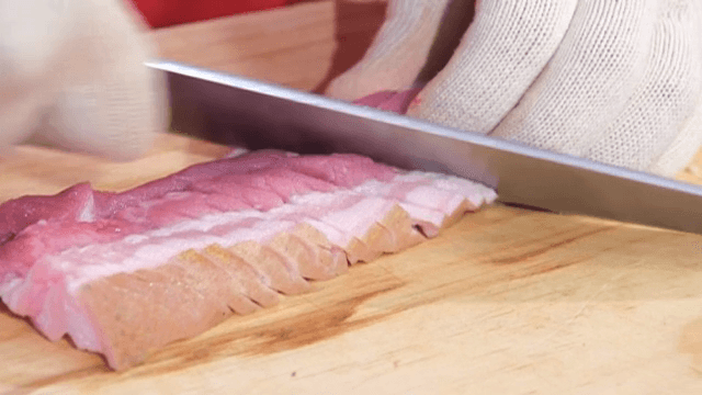 나무 도마 위에서 빠르게 돼지고기 자르기