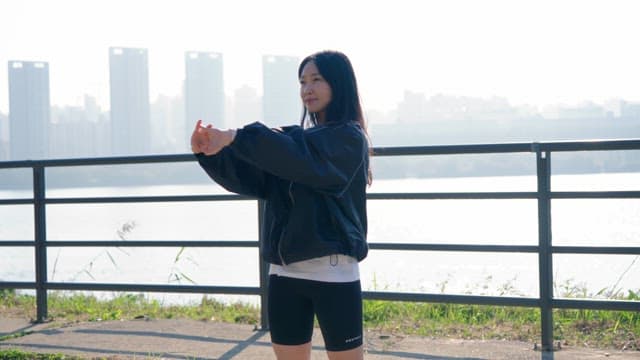 Woman stretching by the riverside