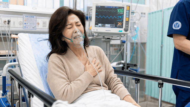 Woman in emergency room bed wearing oxygen mask