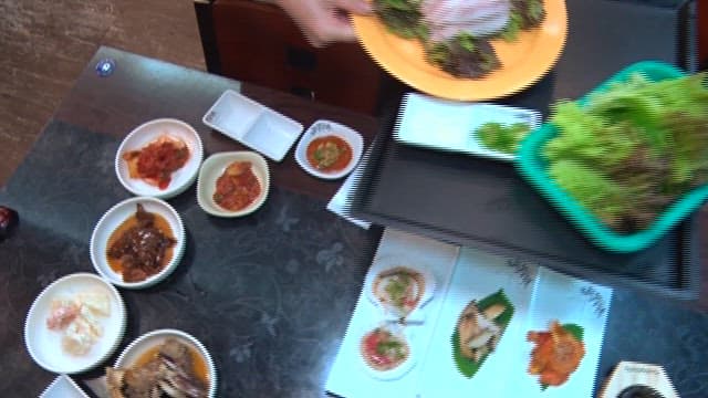 Sliced raw scaled sardine served with various side dishes at a sushi restaurant