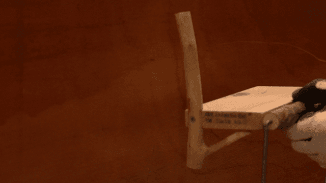 벽에 나무 화장지 홀더의 위치를 잡는 손