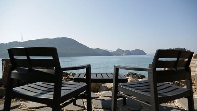 Table and chairs facing the sea