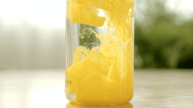 Yellow liquid swirling in a clear bottle