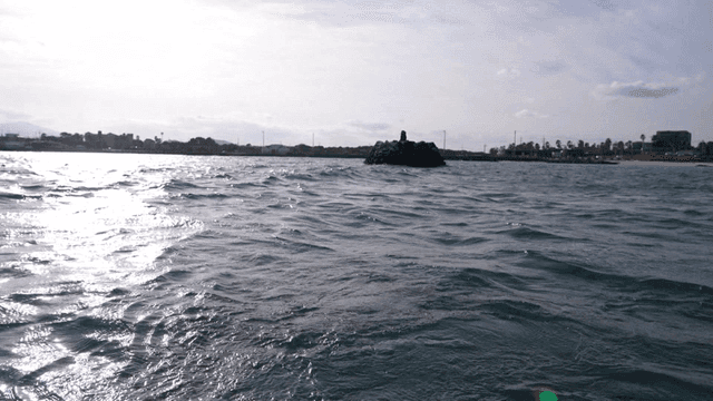 Boat on sea with coast visible in distance