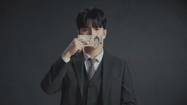 돈으로 입을 가린 채 억울한 표정을 지은 남자