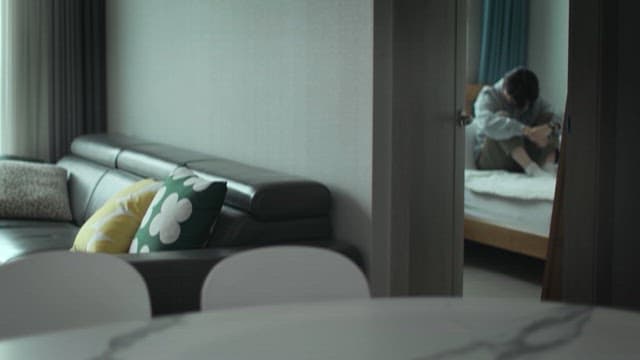 Person Sitting Alone on a Bed in a Room