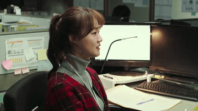 Woman in front of office desk with complicated expression