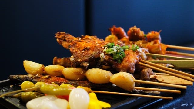 Various types of grilled skewers neatly arranged on an iron plate