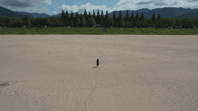 넓은 모래밭을 걷는 여성