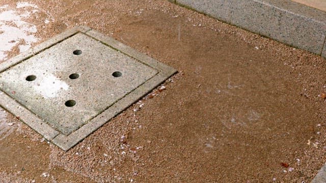 Puddle of water formed when raindrops fall near a drain