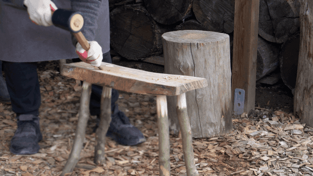 야외에서 나무 의자를 만드는 사람