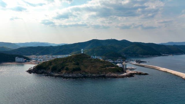 Coastal town with a lighthouse on a hill