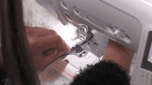 Person sewing fabric with a sewing machine